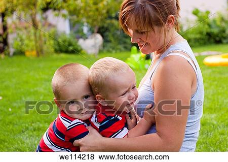Stock Photo - Happy mother and little boys in the garden. Fotosearch