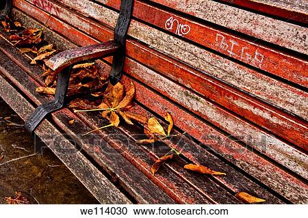 Leaves on a red bench in a park View Large Photo Image Stock Image - Leaves on a red bench in a park. Fotosearch
