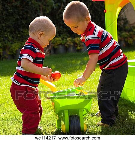 Stock Photo - Little brothers playing in the garden. Fotosearch