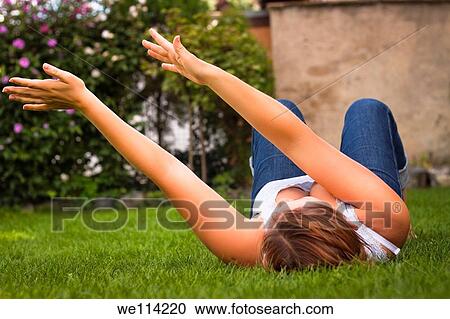 Stock Image - Portrait of a young sexy woman gesturing with hands in the garden. Fotosearch