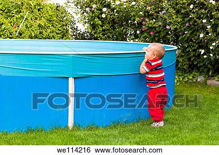 Toddler boy exploring swimming pool in the garden View Large Photo Image Stock Photograph - Toddler boy exploring swimming pool in the garden. Fotosearch