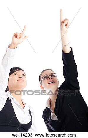 Stock Image - Two young happy business women pointing up, isolated on white background. Fotosearch