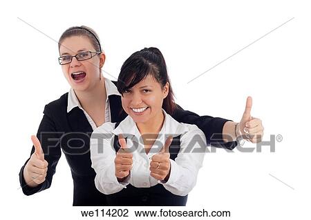 Stock Image - Two young successful business women gesturing thumbs up, isolated on white background. Fotosearch