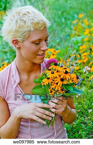 21 year old blond woman in a summer garden holding a bouquet of perennial flowers View Large Photo Image Stock Photography - 21 year old blond woman in a summer garden holding a bouquet of perennial flowers. Fotosearch