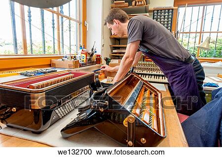 Stock Image - Instrument maker with accordion. Fotosearch