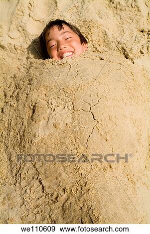 Boy buried in the sand at the beach, Biscarrosse, France. View Large Photo Image Stock Photo - Boy buried in the sand at the beach, Biscarrosse, France.. Fotosearch