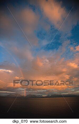 A rainbow in a cloudy sky View Large Photo Image Stock Image - A rainbow in a cloudy sky. Fotosearch