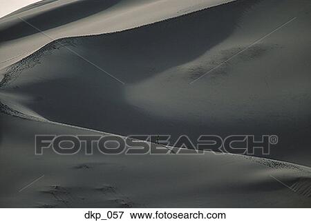 Aerial view of a person walking on a sand dune View Large Photo Image Stock Photo - Aerial view of a person walking on a sand dune. Fotosearch