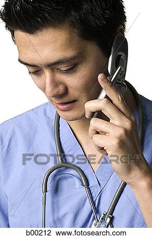 Asian doctor talking on cell phone View Large Photo Image Stock Image - Asian doctor talking on cell phone. Fotosearch
