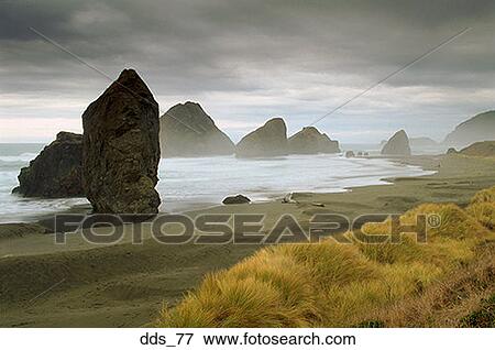 Stock Photo - Beach with large boulders and an overcast sky. Fotosearch