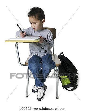 Stock Image - Boy writing on a note pad. Fotosearch