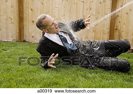 Businessman getting sprayed with water View Large Photo Image Stock Photo - Businessman getting sprayed with water. Fotosearch