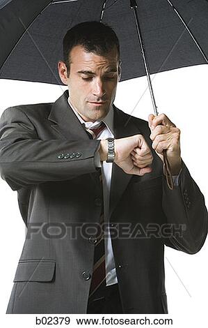 Businessman looking at his wristwatch View Large Photo Image Stock Photo - Businessman looking at his wristwatch. Fotosearch
