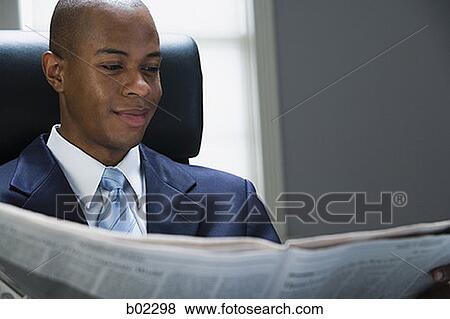 Stock Photo - Businessman reading a newspaper. Fotosearch