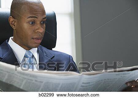 Businessman reading a newspaper View Large Photo Image Stock Photo - Businessman reading a newspaper. Fotosearch