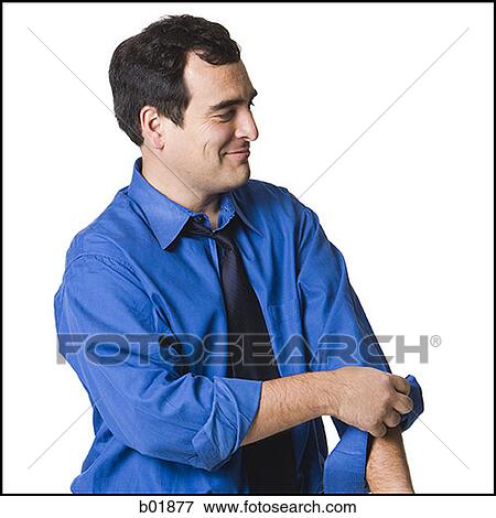 Businessman rolling up his sleeves View Large Photo Image Stock Photo - Businessman rolling up his sleeves. Fotosearch