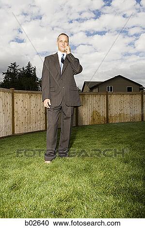 Businessman standing in a lawn View Large Photo Image Stock Image - Businessman standing in a lawn. Fotosearch