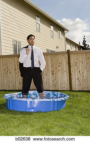 Businessman standing in a wading pool View Large Photo Image Stock Photo - Businessman standing in a wading pool. Fotosearch