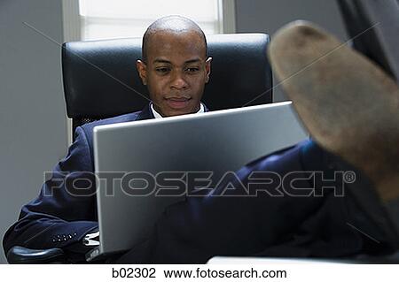 Businessman working on a laptop computer View Large Photo Image Stock Image - Businessman working on a laptop computer. Fotosearch
