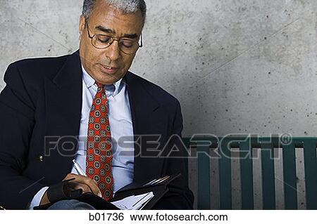 Businessman writing in a diary View Large Photo Image Stock Photograph - Businessman writing in a diary. Fotosearch