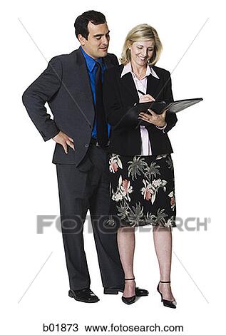 Stock Image - Businesswoman writing in a folder next to a businessman. Fotosearch