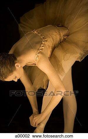 Stock Image - Close-up of a ballerina tying her ballet slipper. Fotosearch