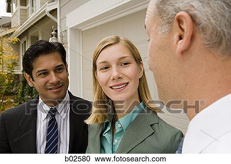 Close-up of a businesswoman and two businessmen smiling View Large Photo Image Stock Image - Close-up of a businesswoman and two businessmen smiling. Fotosearch