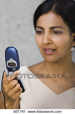 Close-up of a businesswoman looking at a mobile phone View Large Photo Image Stock Image - Close-up of a businesswoman looking at a mobile phone. Fotosearch