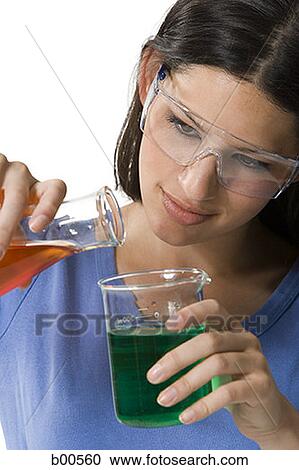 Close-up of a female technician pouring liquid from a conical flask into a beaker View Large Photo Image Stock Image - Close-up of a female technician pouring liquid from a conical flask into a beaker. Fotosearch