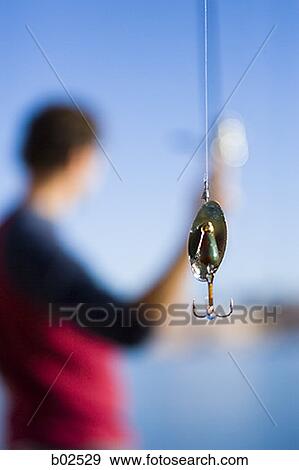 Close-up of a fishing hook hanging on a thread View Large Photo Image Stock Photo - Close-up of a fishing hook hanging on a thread. Fotosearch