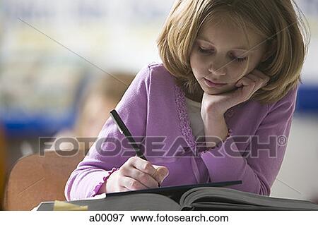 Close-up of a girl at school writing on a note pad View Large Photo Image Stock Photo - Close-up of a girl at school writing on a note pad. Fotosearch