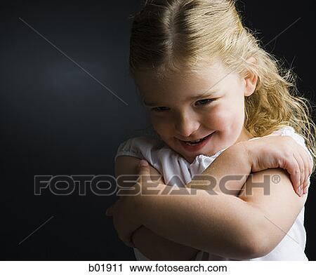 Close-up of a girl smiling with her arms folded View Large Photo Image Stock Image - Close-up of a girl smiling with her arms folded. Fotosearch