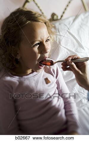 Close-up of a girl taking medicine View Large Photo Image Stock Photo - Close-up of a girl taking medicine. Fotosearch
