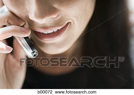 Stock Image - Close-up of a mid adult woman talking on the mobile phone. Fotosearch