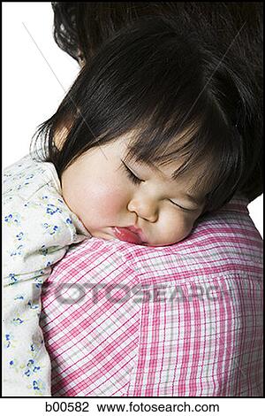 Close-up of a mother carrying her sleeping daughter View Large Photo Image Stock Image - Close-up of a mother carrying her sleeping daughter. Fotosearch