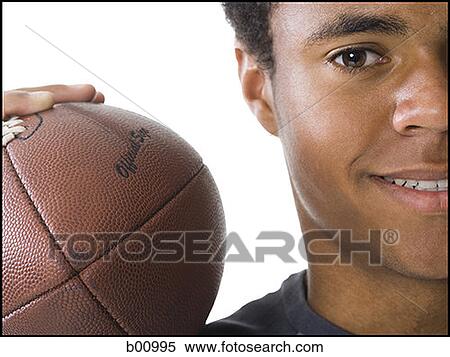 Close-up of a teenage boy holding a football View Large Photo Image Stock Photography - Close-up of a teenage boy holding a football. Fotosearch