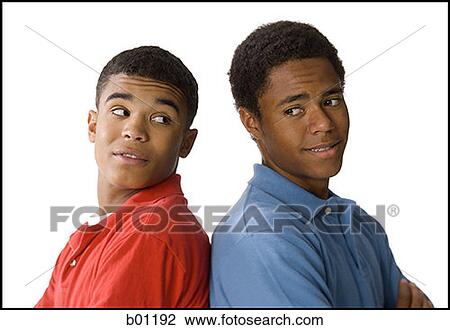 Close-up of a two young men standing back to back View Large Photo Image Stock Image - Close-up of a two young men standing back to back. Fotosearch