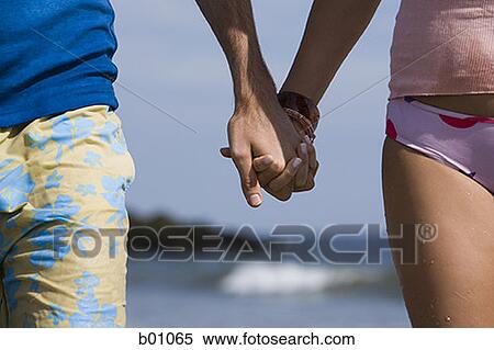 Stock Photography - Close-up of a young couple holding hands. Fotosearch