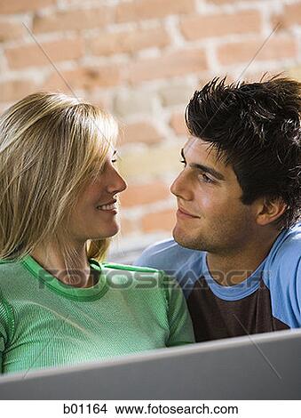 Close-up of a young couple looking at each other View Large Photo Image Picture - Close-up of a young couple looking at each other. Fotosearch