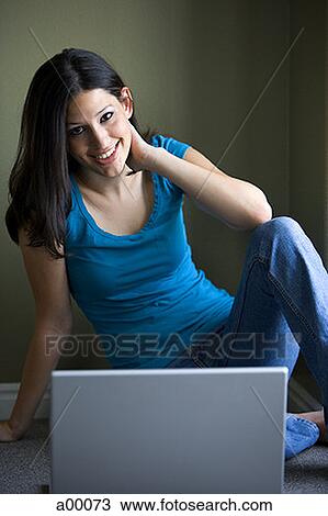 Stock Image - Close-up of a young Latin woman sitting in front of a laptop. Fotosearch