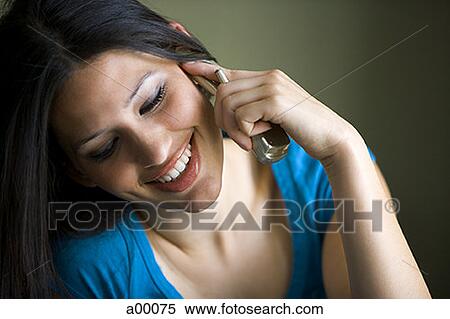 Stock Photography - Close-up of a young Latin woman talking on a mobile phone. Fotosearch