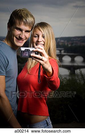 Close-up of a young man and a young woman photographing themselves View Large Photo Image Picture - Close-up of a young man and a young woman photographing themselves. Fotosearch