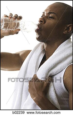 Close-up of a young man drinking water from a bottle View Large Photo Image Stock Photo - Close-up of a young man drinking water from a bottle. Fotosearch