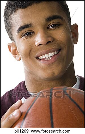 Close-up of a young man holding a basketball View Large Photo Image Stock Photo - Close-up of a young man holding a basketball. Fotosearch