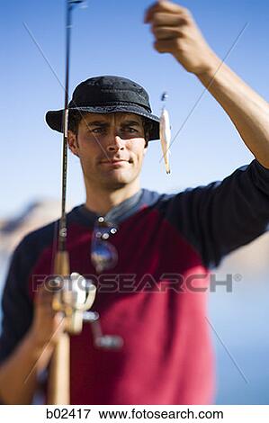 Close-up of a young man holding a fishing bait View Large Photo Image Stock Photo - Close-up of a young man holding a fishing bait. Fotosearch
