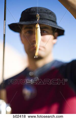 Close-up of a young man looking at a fishing bait View Large Photo Image Stock Photo - Close-up of a young man looking at a fishing bait. Fotosearch