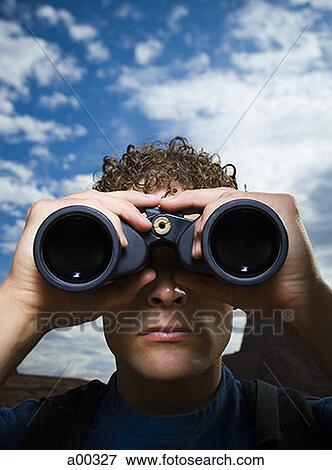 Stock Photo - Close-up of a young man looking through binoculars. Fotosearch