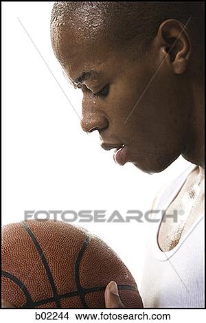 Close-up of a young man preparing to shoot a basketball View Large Photo Image Picture - Close-up of a young man preparing to shoot a basketball. Fotosearch