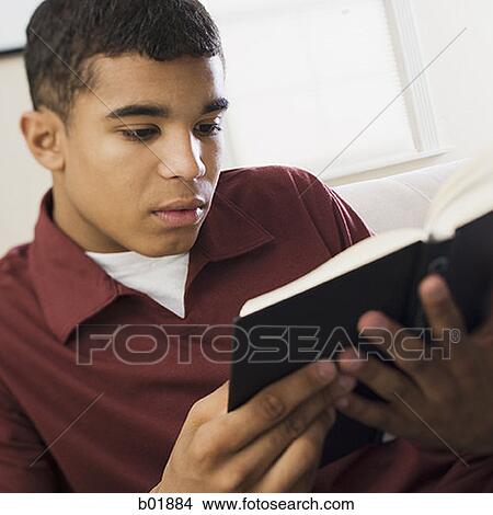 Picture - Close-up of a young man reading a book. Fotosearch