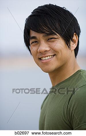 Close-up of a young man smiling View Large Photo Image Stock Photo - Close-up of a young man smiling. Fotosearch